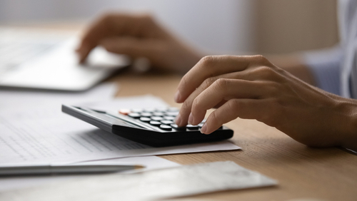 Close,up,young,woman,using,calculator,,managing,household,monthly,budget,